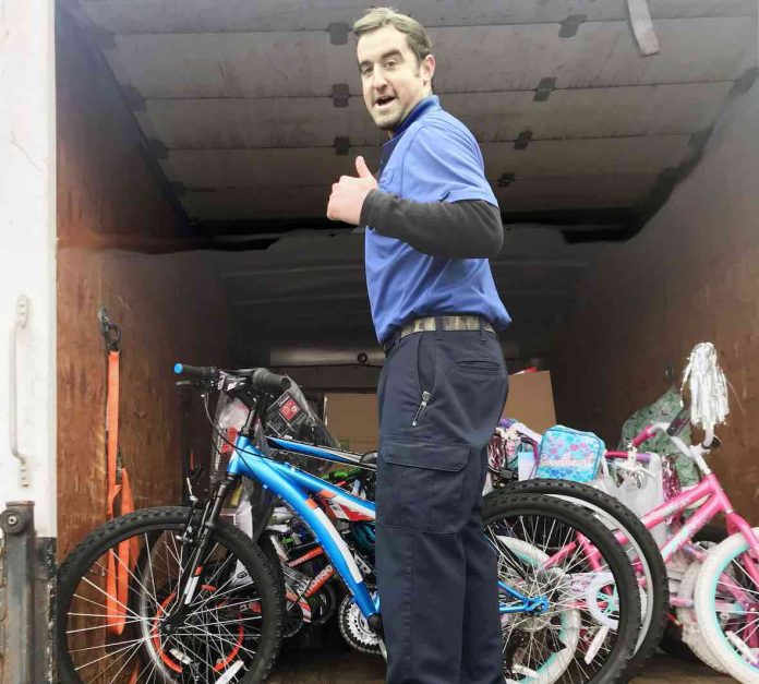 Warehouse employee Chase Callahan gives a big thumbs up as he loads bicycles inside his delivery truck. The bicycles are fulfilling the wishes of students included in this year’s CARE Angel Project. Photo/Fayette County School System.