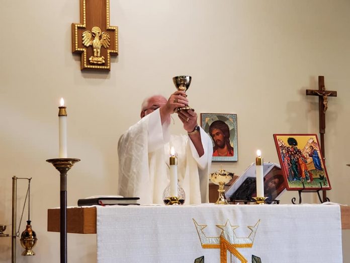 Rector David Epps prepares Communion. Photo/Submitted.