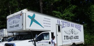 A Better Way Movers Office Manager John Kidney with one of the signature moving trucks at the company's Peachtree City location on Dividend Drive. Photo/Ben Nelms.