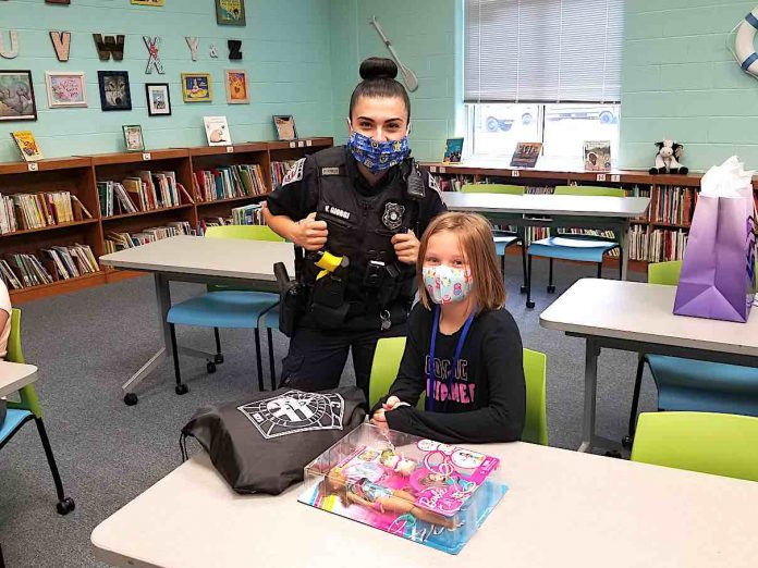 Emmerson Perkins, fourth grade, shows off her Spin ‘n Twirl Gymnast Barbie doll set she received from Fayetteville police officers for her positive behavior and actions.