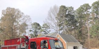 The jolly elf in the red suit was conveyed through Peachtree City neighborhoods Sunday courtesy of the Peachtree City Fire Department. His reindeer were unavailable for comment on the antique mode of transportation. Photo/Joyce Beverly.