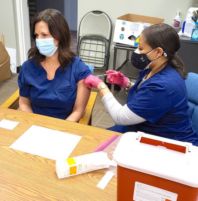 Rising Starr Middle school nurse Tiffany Blair receives the Moderna Covid-19 vaccination from a nurse at the Fayette County Health Department. Photo/Fayette County School System.