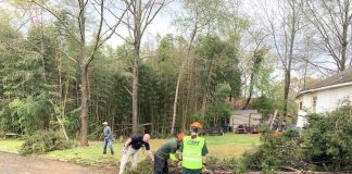 Members of the all-volunteer CERT team from the Peachtree City Police Department help clean up at one tornado-damaged home.