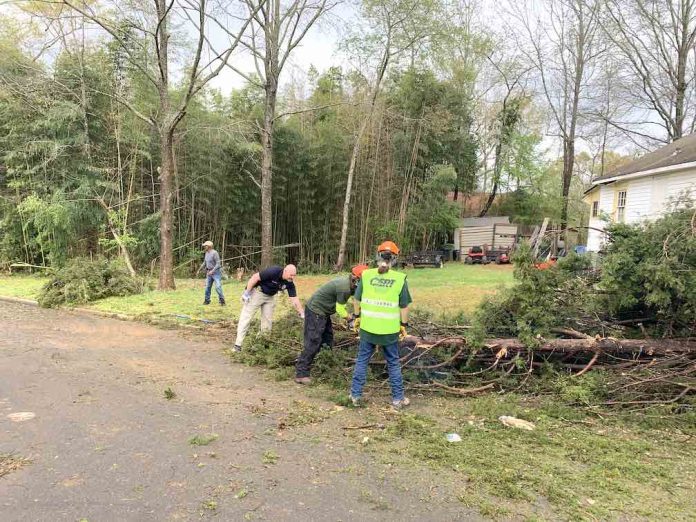 Members of the all-volunteer CERT team from the Peachtree City Police Department help clean up at one tornado-damaged home.