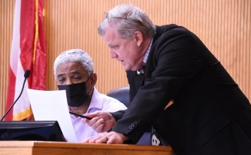 Fayette County Commissioner Charles Rousseau (L) and County Administrator Steve Rapson discuss agenda item before the regular meeting May 13. Photo/Cal Beverly.