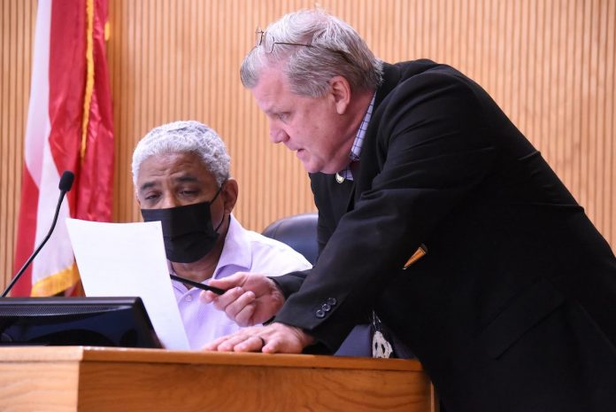 Fayette County Commissioner Charles Rousseau (L) and County Administrator Steve Rapson discuss agenda item before the regular meeting May 13. Photo/Cal Beverly.