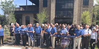 The Fayetteville City Council and City Manager Ray Gibson, all in blue shirts, cut the ribbon July 14 signifying the grand opening of the new Fayetteville City Hall on West Stonewall Avenue. They were joined for the event by a large group of Fayetteville staff and citizens, and elected officials from throughout Fayette County. Photo/Ben Nelms.