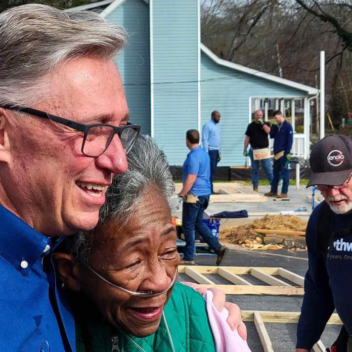 Ms. Derryl Anderson (with Rick Halbert) looks on as her new home receives finishing touches. Photo/City of Fayetteville, Ga.