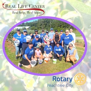 Rotarians help gather produce for needy families...